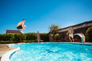 young-cheerful-friends-smiling-relaxing-jumping-swimming-pool